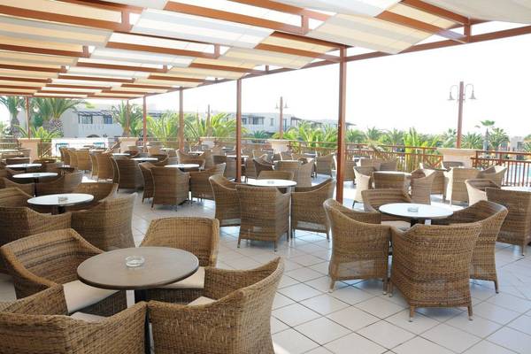 Terrasse des Porto Bello Beach Hotels mit vielen Tischen und Stühlen im Freien