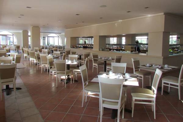 Frühstücksraum des Porto Bello Beach Hotels mit vielen Tischen und Stühlen.