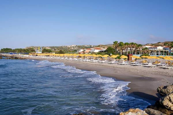 Porto Bello Strand mit gelb gestreiften Sonnenhüten und Liegestühlen am Meer