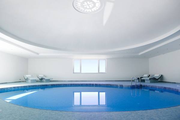 Innenpool des Elounda Village Resort & Spa mit weißen Wänden und blauem Wasser