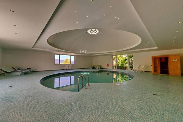 Poolbereich des Elounda Village Resort & Spa mit runden Kacheln und Liegestühlen