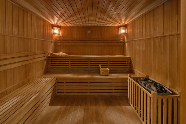 Innenansicht der Sauna im Elounda Village Resort & Spa mit Holzwänden und Bänken.