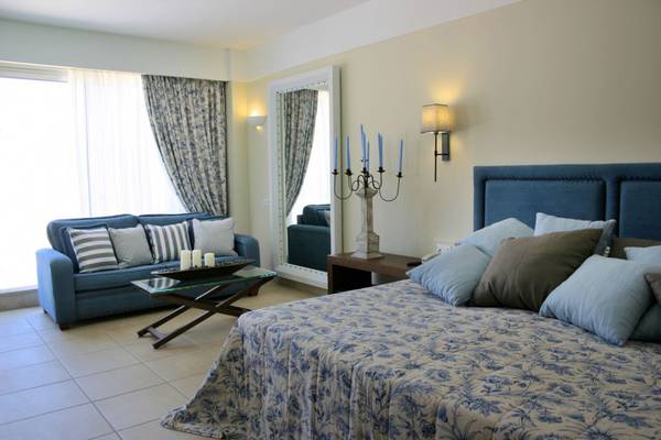 Schlafzimmer mit Sofa und Spiegel im Elounda Village Resort & Spa