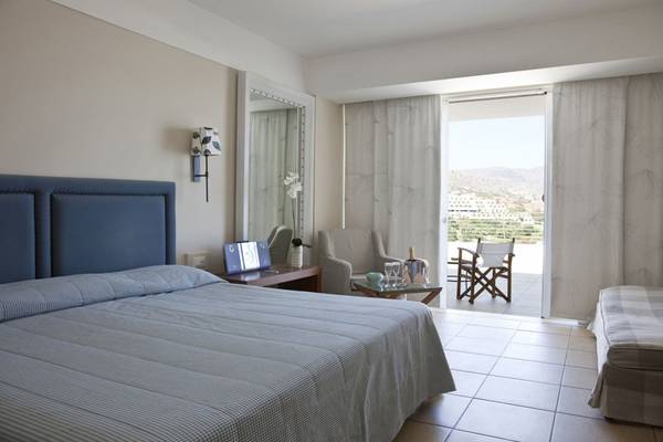 Ein elegantes Hotelzimmer im Elounda Village Resort & Spa mit Blick auf die Berge.