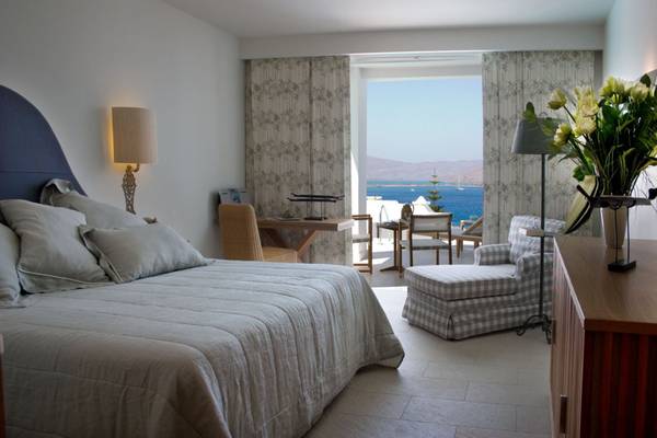 Schlafzimmer im Elounda Village Resort & Spa mit Blick auf das Meer und Möbeln.