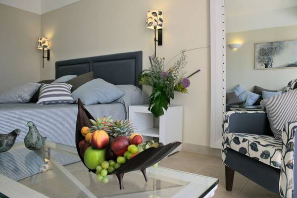 Schlafzimmer im Elounda Village Resort & Spa mit Bett, Früchtekorb und Dekor