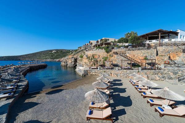 Strand mit Liegen und Umbrellas im Elounda Village Resort & Spa