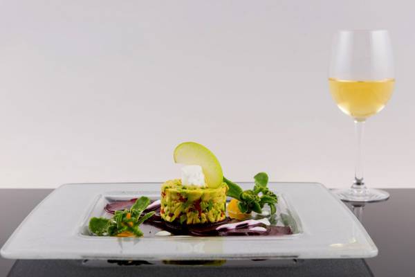 Gedeckter Tisch im Elounda Village Resort mit einem Gericht und einem Glas Wein
