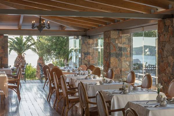 Innenansicht des Restaurants im Elounda Village Resort & Spa mit Blick auf den Ozean.