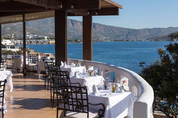 Terrasse des Elounda Village Resorts mit Blick auf das Meer und Berge.