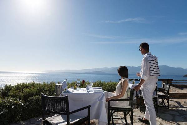 Außentisch im Elounda Village Resort & Spa mit Blick auf das Meer.