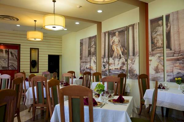 Innenbereich des Restaurants im Sanctuary at Grand Memories Varadero mit gedeckten Tischen und Wandgemälden.