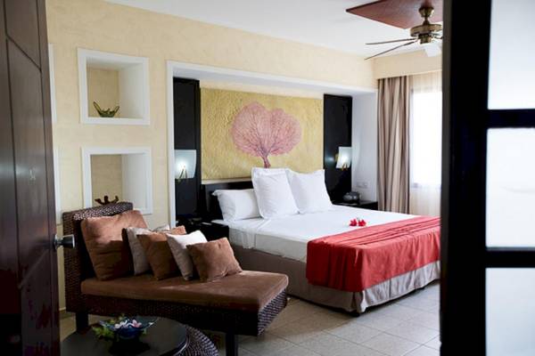 Hotelzimmer im Sanctuary at Grand Memories Varadero mit Bett, Sofa und Wandkunst.