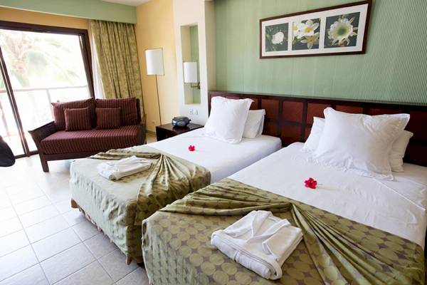Doppelbett-Zimmer im Sanctuary at Grand Memories Varadero mit Couch, Blumen und Fenstern
