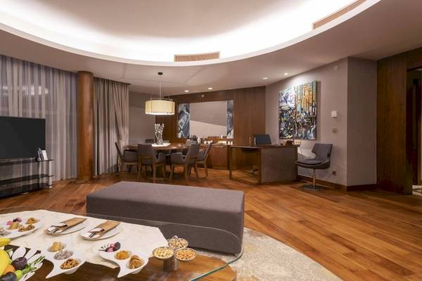 Wohnzimmer des Concorde De Luxe Resorts mit Fernseher, Esstisch und Frühstücksbuffet.