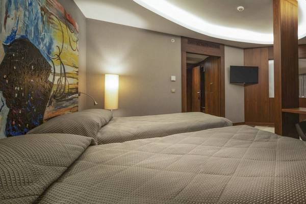 Schlafzimmer im Concorde De Luxe Resort mit zwei Betten, einem Schreibtisch und einem Fernseher.