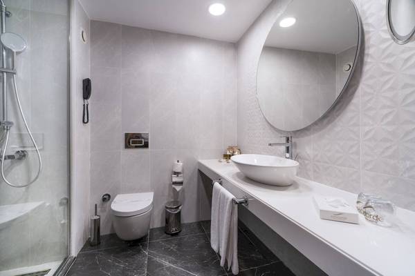 Das Badezimmer des Concorde De Luxe Resort mit einer Dusche, Toilette, Waschbecken und Spiegeln.
