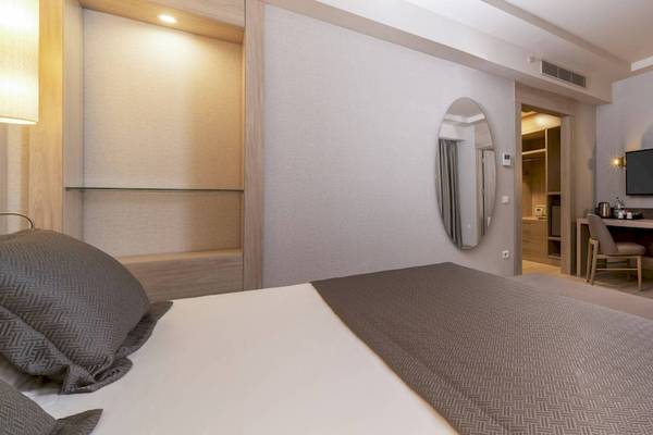 Innenansicht eines Hotelzimmers im Concorde De Luxe Resort mit Bett, Schreibtisch, Fernseher und Spiegel.