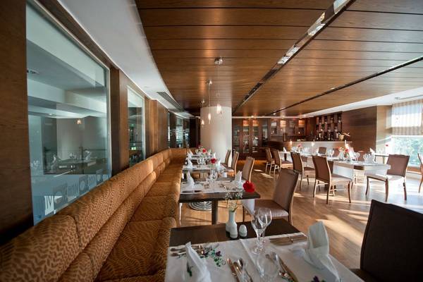 Innenbereich des Concorde De Luxe Resort Restaurants mit gepolsterten Bänken und gedeckten Tischen.