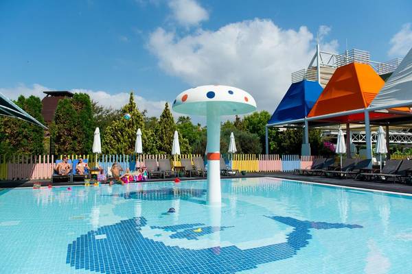 Außenpool des Concorde De Luxe Resort mit bunten Sonnenschirmen und Liegen
