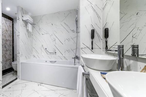 Badezimmer im Concorde De Luxe Resort mit Marmorfliesen, Badewanne und Dusche
