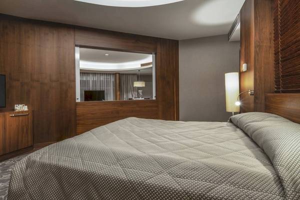 Schlafzimmer im Concorde De Luxe Resort mit Fernseher und Holzmöbeln