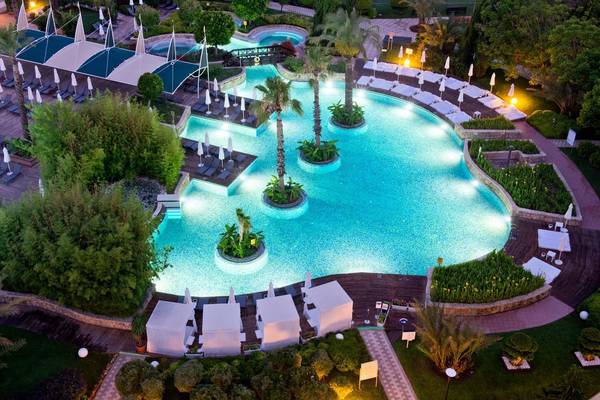 Luftaufnahme des Poolbereichs im Concorde De Luxe Resort mit mehreren Schwimmbecken und Sonnenliegen.
