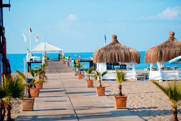 Weg am Strand des Concorde De Luxe Resorts mit Palmen und Pavillons