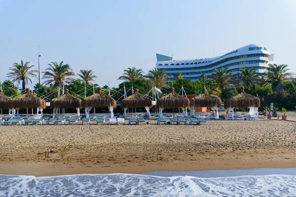 Strand des Concorde De Luxe Resorts mit Sonnenliegen und Palmen