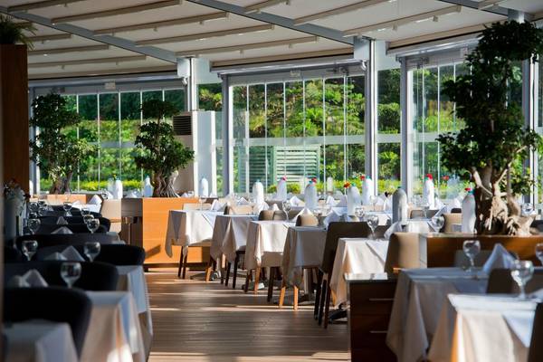 Restaurant des Concorde De Luxe Resort mit großen Fenstern und Blick auf den Garten