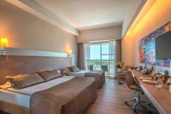 Hotelzimmer im Concorde De Luxe Resort mit zwei Betten, Schreibtisch und Ausblick auf den Ozean.
