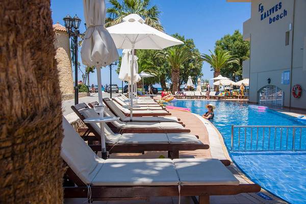 Poolbereich des Kalyves Beach Hotels mit Lounge-Stühlen und Sonnenschirmen