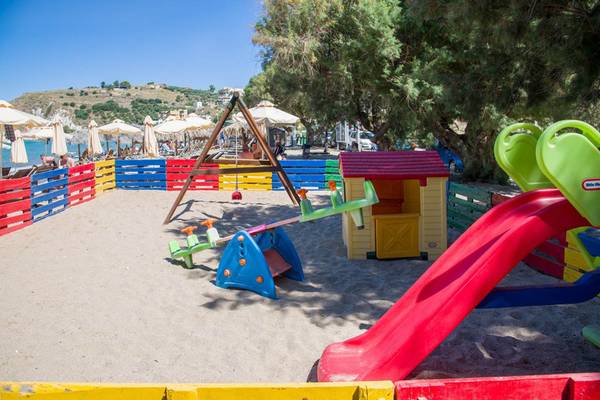 Kinderspielplatz am Strand des Kalyves Beach Hotels mit bunten Spielgeräten.