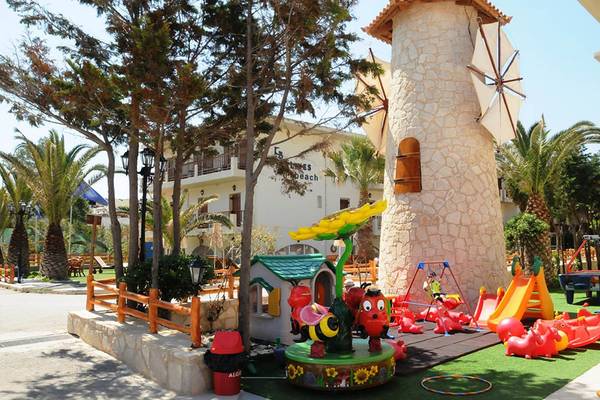 Ein Kinderspielplatz vor dem Kalyves Beach Hotel mit einer Mühle und vielen Spielgeräten.