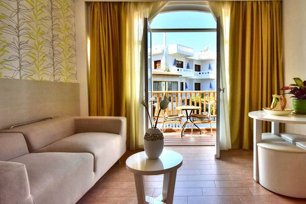 Wohnzimmer mit Sofa und Balkon im Kalyves Beach Hotel.