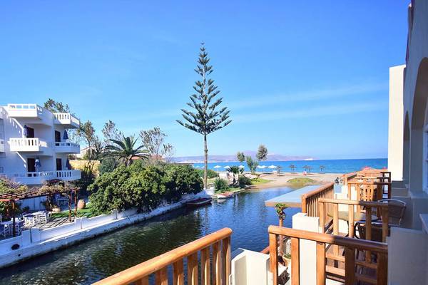 Aussicht vom Balkon des Kalyves Beach Hotels auf eine Bucht und eine Straße.