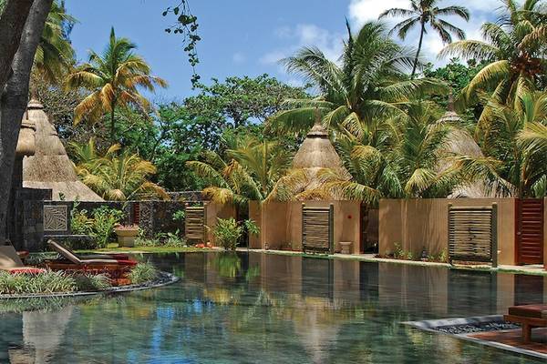 Außenpool mit Lounge-Stühlen und Pflanzen im Shandrani Beachcomber Resort & Spa.