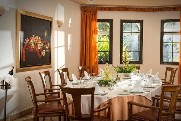 Ein formelles Esszimmer im Hersonissos Maris Hotel mit Tisch, Stühlen und Dekor.