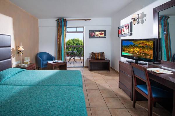 Doppelzimmer im Hersonissos Maris Hotel mit zwei Betten, Fernseher, Schreibtisch und Balkon.