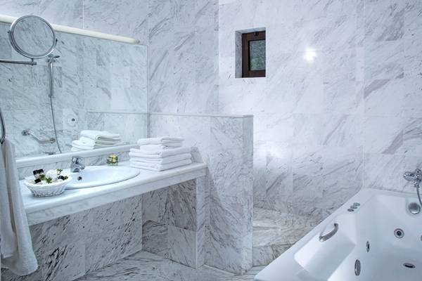 Badezimmer im Hersonissos Maris Hotel mit weißen Marmorfliesen und einer Badewanne.
