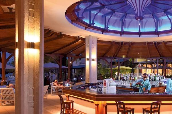 Bar im Shandrani Beachcomber Resort & Spa mit Barkeeper und Gästen