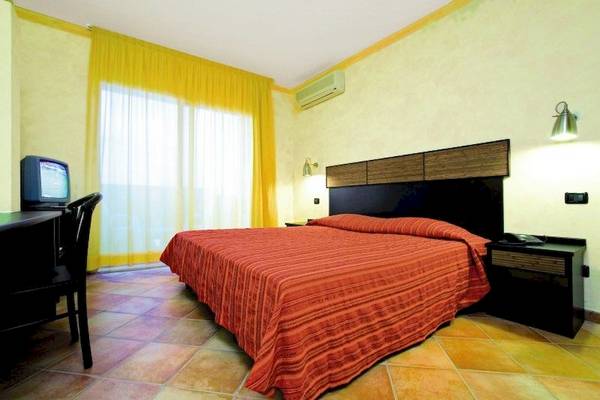 Zimmer im Occidental Boa Vista Beach Hotel mit einem Bett, Fernseher, Schreibtisch und Stühle.