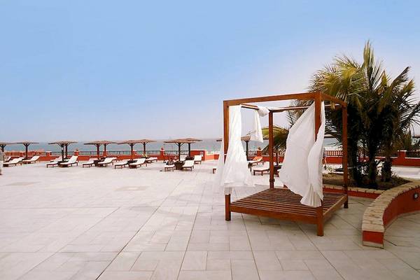 Außenbereich des Occidental Boa Vista Beach Hotels mit Loungebereich und Sonnenliegen.