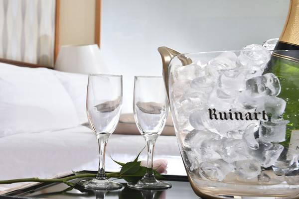 Zimmer im Pioneer Beach Hotel mit Champagnerflasche und Gläsern auf Eis in einem Eiswürfeleimer.