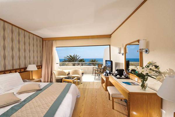 Zimmer im Pioneer Beach Hotel mit Blick auf das Meer und eine Terrasse.
