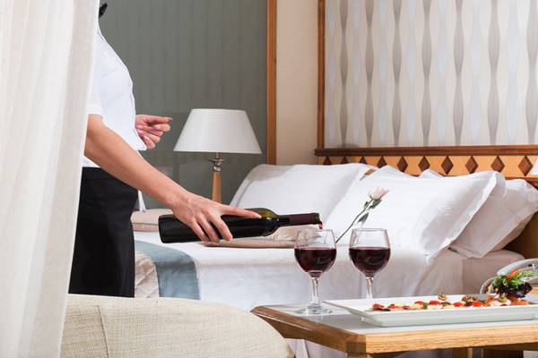 Zimmerservice im Pioneer Beach Hotel mit Wein und Gericht auf einem Tisch.