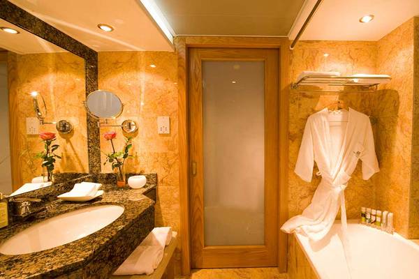 Badezimmer im Pioneer Beach Hotel mit Badewanne, Handtüchern und Toilettenartikeln.