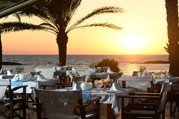 Sonnenuntergang am Meer mit einem gedeckten Tisch im Freien im Pioneer Beach Hotel.