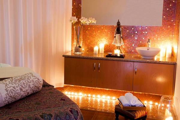 Spa-Behandlungsraum im Pioneer Beach Hotel mit Kerzen, einem Waschbecken und einem Bett.
