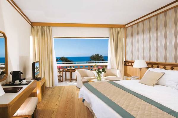 Hotelzimmer des Pioneer Beach Hotel mit Blick auf das Meer und die Terrasse.